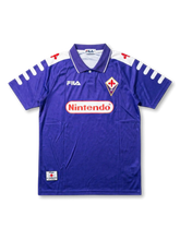Front view of Fiorentina 1998-99 home shirt with purple body, Nintendo sponsor, Fiorentina crest, Fila logo, and white shoulder detailing.