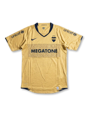 Front view of Boca Juniors 2007-08 away shirt with gold body, navy trim, Megatone sponsor, Boca Juniors crest, and UNICEF sleeve branding.