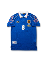 Front view of Japan 1998 World Cup home shirt with blue body, flame sleeve graphics, JFA crest, France 98 chest detail, and #8 front number.