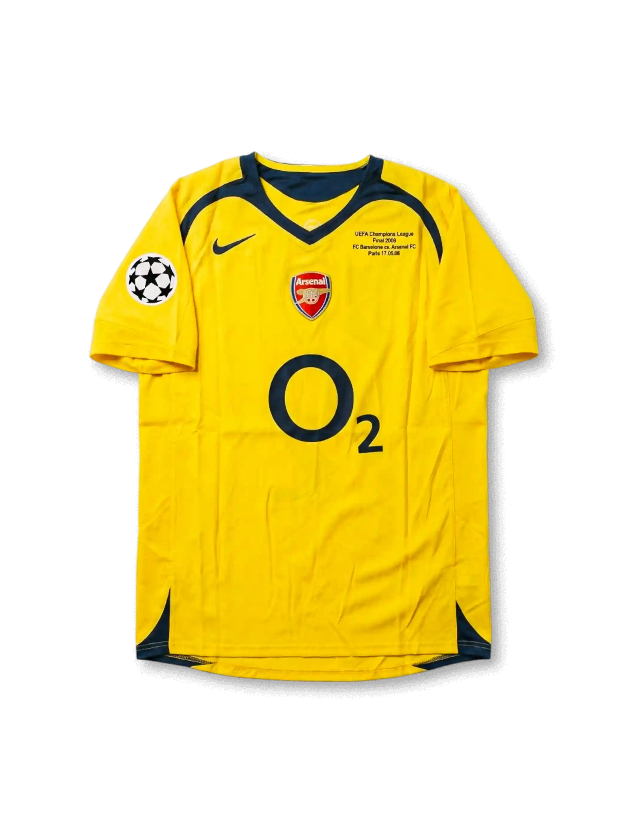 Front view of Arsenal 2006 Champions League Final away shirt with yellow body, O2 sponsor, Arsenal crest, Paris final match detail, and UEFA sleeve patch.