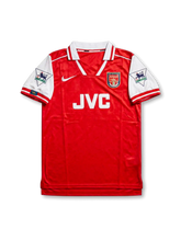 Front view of Arsenal 1995-96 home shirt with red body, white sleeves, JVC sponsor, club crest, and Premier League sleeve patches.