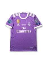 Front view of Real Madrid 2017 Final Cardiff purple shirt with club crest, Fly Emirates sponsor, final text, white shoulder stripes, and sleeve patches.