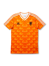 Front view of Netherlands 1988 home shirt with orange geometric pattern, white V-neck collar, white shoulder stripes, and black crest detail.