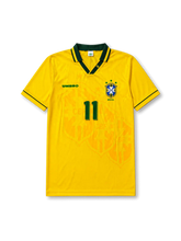 Front view of Brazil 1994 World Cup home shirt with yellow body, green collar trim, Brazil crest, #11 chest number, and tonal crest pattern.