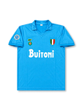 Front view of Napoli 1987-88 home shirt with sky-blue body, Buitoni sponsor, Scudetto shield, Napoli sleeve patch, and fold-over collar.