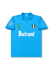 Front view of Napoli 1987-88 home shirt with sky-blue body, Buitoni sponsor, Scudetto shield, Napoli sleeve patch, and fold-over collar.