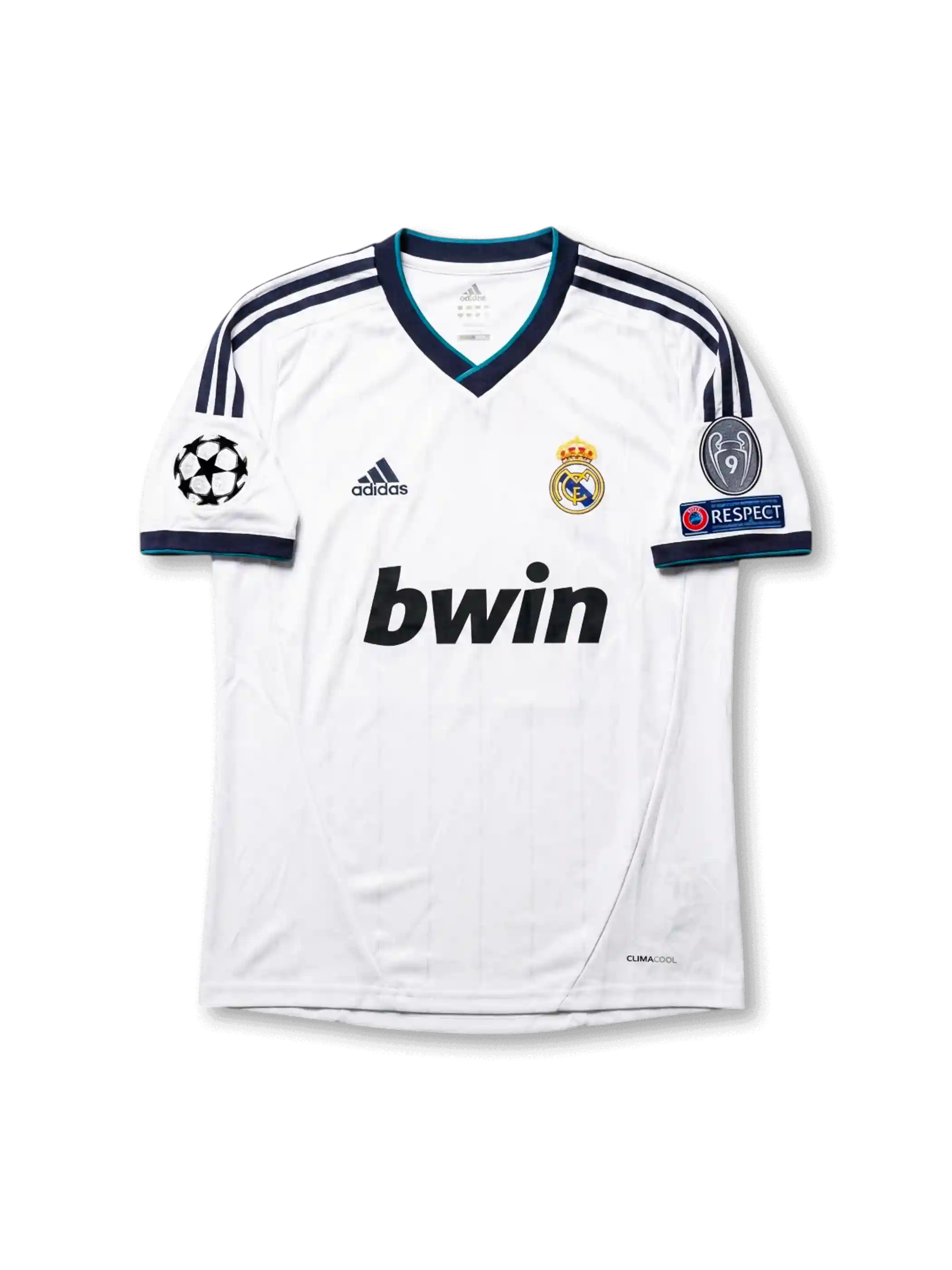 Front view of Real Madrid 2012-13 home jersey with white base, navy shoulder stripes, teal trim, club crest, sponsor, and Champions League sleeve patches.