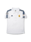 Front view of Real Madrid 1998-00 home shirt with white base, club crest, dark navy shoulder stripes, and Champions League sleeve patch.