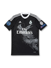 Front view of Real Madrid 2014-15 Yohji Yamamoto black third jersey with dragon graphic, Fly Emirates sponsor, monochrome club crest, Champions League sleeve patches, and white shoulder stripes.