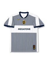 Front view of Boca Juniors 2006-07 away jersey with white and navy pinstripe design, Megatone sponsor, club crest, yellow swoosh detail, and navy collar trim.
