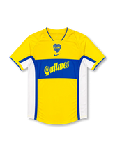 Front view of Boca Juniors 2000s away shirt with yellow base, blue chest band, CABJ crest, Quilmes sponsor, and white side panels.