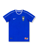 Front view of Brazil 1990s away shirt with royal blue base, CBF crest, white shoulder piping, white sleeve trim, and lower hem label detail.