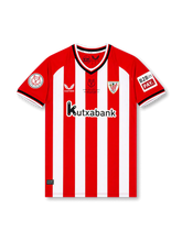 Front view of Athletic Club 2023-24 home shirt with red and white stripes, club crest, Kutxabank sponsor, Copa del Rey sleeve patch, and commemorative chest detail.