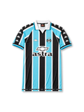 Front view of Grêmio 2000 home shirt with black, sky blue, and white vertical stripes, club crest, Astra sponsor, Chevrolet logo, and white fold collar.
