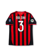 Back view of AC Milan Maldini #3 legacy edition shirt with Maldini name and #3 printing, red and black striped design, gold AC Milan neck detail, and sleeve patches.