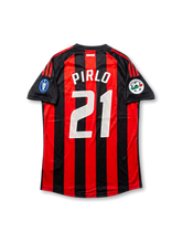 Back view of AC Milan Pirlo #21 legacy edition shirt with red and black stripes, white player printing, black sleeve panels, and sleeve patch detailing.