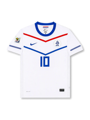 Front view of Netherlands 2010 World Cup away shirt with white base, blue collar, red and blue chevron graphics, KNVB crest, central #10 print, and South Africa 2010 sleeve patch.
