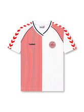 Front view of Denmark 1986 World Cup away shirt with white base, red pinstripe half-panel design, DBU crest, V-neck collar, and red chevron sleeve detailing.