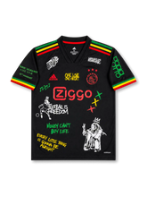 Front view of Ajax 2021-22 Bob Marley special edition shirt with black base, red yellow and green shoulder stripes, Ajax crest, Ziggo sponsor, and reggae-inspired graphic artwork.