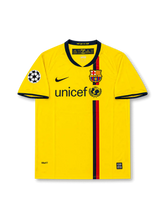 Front view of Barcelona 2008-09 away shirt with yellow body, central red and navy stripe, club crest, UNICEF sponsor, and Champions League sleeve patch.