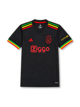 front view of Ajax 2021-22 Bob Marley tribute shirt with black base, red yellow and green sleeve detailing, Ajax crest, sponsor print, and Curaçao sleeve mark