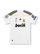 front view of Real Madrid 2009-10 home shirt with white base, bwin sponsor, club crest, yellow trim, Champions League patch, and UEFA Respect sleeve patch
