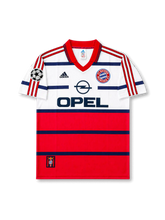 front view of Bayern Munich 1998-00 away shirt with white and red color blocking, Opel sponsor, Bayern crest, adidas logo, and Champions League sleeve patch