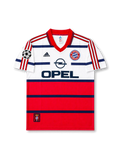front view of Bayern Munich 1998-00 away shirt with white and red color blocking, Opel sponsor, Bayern crest, adidas logo, and Champions League sleeve patch