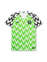 front view of Nigeria 2018 World Cup home shirt with green zigzag pattern, black and white graphic sleeves, Nigeria crest, and V-neck collar