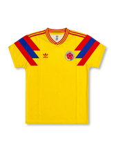 front view of Colombia 1990 World Cup home shirt with yellow body, red and blue shoulder graphics, adidas trefoil logo, and Colombia crest