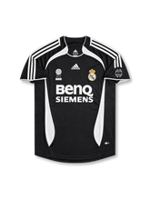 Real Madrid 2006-07 away jersey featuring David Beckham #23, black adidas soccer shirt with white three-stripe shoulder detailing, curved white side panels, white-trimmed crew neck collar, BenQ Siemens sponsor logo, Real Madrid club crest, FIFA Best Club of the 20th Century commemorative badge, and BECKHAM name with white number 23 on the back.