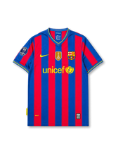 front view of Barcelona 2009-10 home shirt with blue and garnet vertical stripes, UNICEF sponsor, Barcelona crest, Nike logo, FIFA champions badge, and Champions League sleeve patch