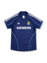 Real Madrid 2005-06 away jersey, front view, navy with light blue piping, open V-notch collar, white shoulder stripes, adidas logo, club crest, white Siemens sponsor