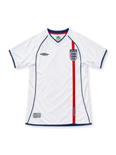 England 2002 home jersey, front view, white with navy V-neck and piping, vertical red stripe, Three Lions crest, navy Umbro logo, navy cuffs and hem
