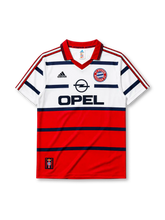 Bayern Munich 1998-2000 away jersey, front view, white upper body and red lower body with navy horizontal stripes, red V-neck collar, black adidas logo, FC Bayern Munchen crest, navy Opel sponsor logo, small tag near bottom hem