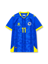 Front view of Bosnia and Herzegovina 2026 home shirt with Edin Džeko #11, federation crest, and tonal blue graphic design.