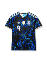 Front view of Argentina 2026 away shirt with Julián Álvarez #9, AFA crest, centered gold FIFA champions badge, and black-and-blue ornamental design.