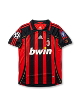 Front view of AC Milan home shirt in black and red stripes with bwin sponsor, adidas logo, club crest, gold star, and European competition sleeve patches.