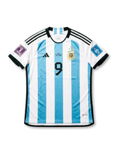 Front view of Argentina 2022 FIFA World Cup Final home shirt with sky blue and white stripes, black number 9, AFA crest, black shoulder stripes, final embroidery, and Qatar 2022 sleeve patches.