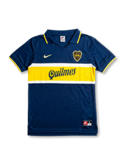 Front view of Boca Juniors home shirt in blue with yellow chest band, Quilmes sponsor, yellow swoosh, CABJ crest, and fold-over collar.