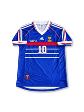 France 1998 FIFA World Cup home jersey featuring Thierry Henry #12, adidas blue soccer shirt with a red chest band, thin white horizontal stripes, white V-neck collar, red white and blue shoulder stripes, France national team rooster crest, white front number 12, and HENRY name with number 12 on the back.