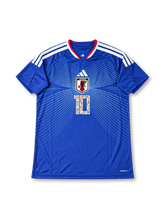 サッカー日本代表 2006年ホームデザイン キャプテン翼 大空翼10番スペシャルエディション adidas製ジャパンブルーのボディにJFAエンブレムから広がるホワイトの放射状ライン、白いスリーストライプス、レッドとホワイトのVネック、漫画イラスト入りの胸番号10、背面のキャプテン翼ロゴと漫画柄の大型10番、日本国旗パッチを配したサッカージャージ