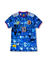 日本代表 ドラゴンボール コラボデザイン 孫悟空10番 スペシャルエディション サッカーユニフォーム。鮮やかなブルーのボディにドラゴンボールの漫画コマ風グラフィックを全面に配し、ホワイトの肩ライン、レッドの襟と袖口、JFAエンブレム、胸元のドラゴンボールロゴとキャラクター柄入り10番を組み合わせた特別デザインのサッカージャージ。