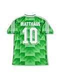 Front view of Germany 1990 World Cup away shirt with green geometric pattern, Germany crest, white V-neck collar, and white shoulder stripes.