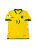 ブラジル代表 2006年ワールドカップ ホームユニフォーム ロナウジーニョ10番。Nike製のカナリアイエローのボディにグリーンのVネックと袖口を組み合わせ、胸元にグリーンのNikeロゴ、5つ星付きCBFエンブレム、グリーンの10番を配したレトロサッカージャージ。ドイツワールドカップ2006の袖章を備え、背面にはRONALDINHOのネームとグリーンの10番をあしらったデザイン。