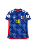 Front view of Japan 2022 World Cup home shirt with blue origami-inspired pattern, Japan crest, yellow #10 print, red trim, and Qatar 2022 sleeve patch.