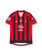 Front view of AC Milan 1999-00 home jersey with red and black stripes, Opel sponsor, Scudetto shield, club crest, and sleeve patches.