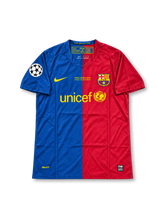FCバルセロナ 2009年ローマ UEFAチャンピオンズリーグ決勝 スペシャルエディションユニフォーム サミュエル・エトー9番。Nike製のブルーとレッドを左右に大胆に切り替えたホームデザインに、イエローのNikeロゴ、クラブエンブレム、UNICEFスポンサーロゴを配置。胸元にはFINAL ROMA 2009の決勝記念刺繍、袖にはUEFAチャンピオンズリーグのパッチを備え、背面にはETO'Oのネームとイエローの9番をあしらった、2009年欧州決勝をモチーフにした特別仕様のサッカージャージ。