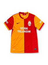 Galatasaray 2013-14 home jersey featuring Didier Drogba #11, Nike red and yellow half-and-half soccer shirt with a two-tone crew neck collar and sleeve cuffs, Türk Telekom sponsor logo, Nike Swoosh, Galatasaray club crest, and DROGBA name and number 11 on the back.