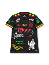 Ajax 2021-22 Bob Marley tribute soccer jersey by adidas, featuring a black body with red, yellow and green shoulder stripes and sleeve cuffs, red Ziggo sponsor logo, three-star Ajax crest, three little birds motif below the back collar, and MARLEY name with a yellow number 10 outlined in reggae-inspired colors on the back.